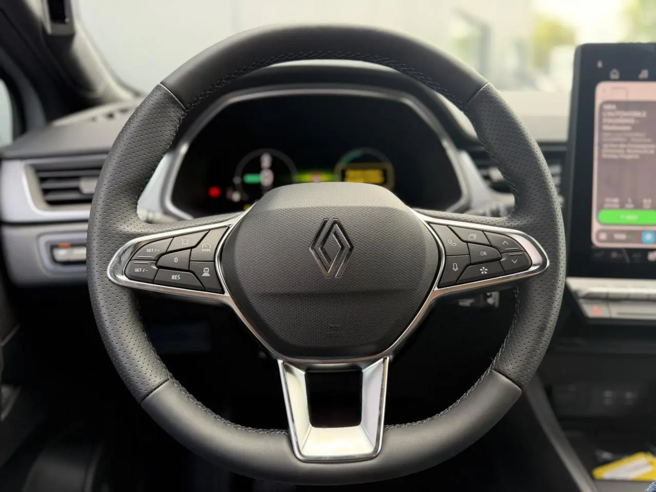 Volant en textile noir avec commandes intégrées et logo Renault au centre, intérieur du Renault Captur 2026.