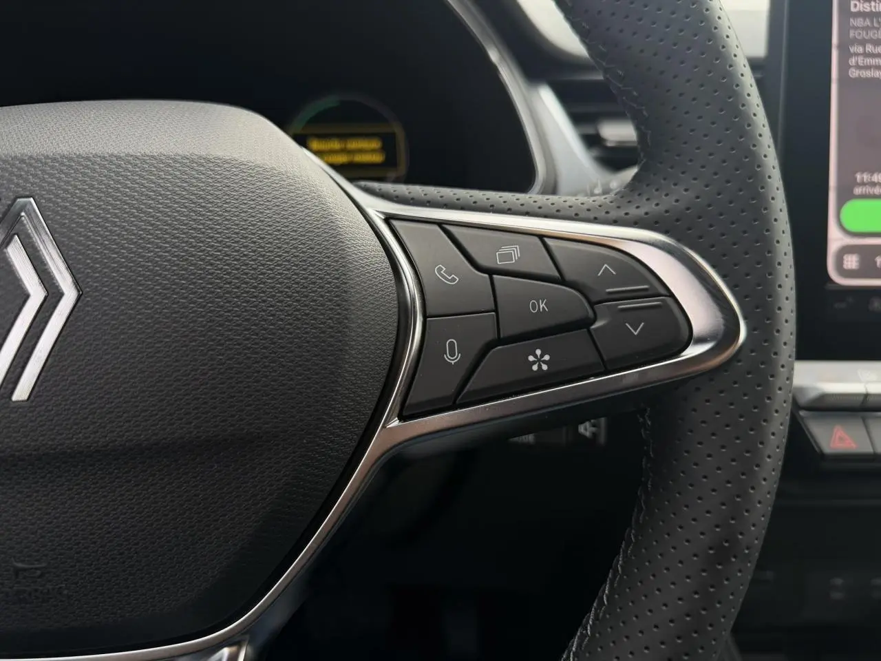 Gros plan sur le volant perforé noir du Renault Captur 2026 avec commandes multifonctions côté droit et logo central.