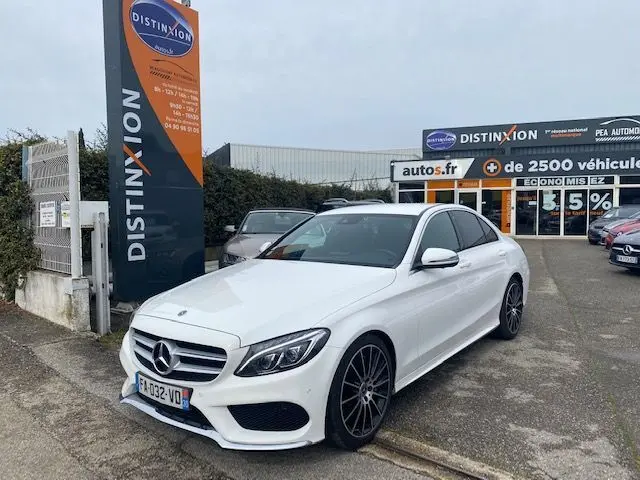 Mercedes Classe C 250D 2018 blanche vue 3/4 avant droit avec jantes noires, stationnée devant un concessionnaire Distinxion.