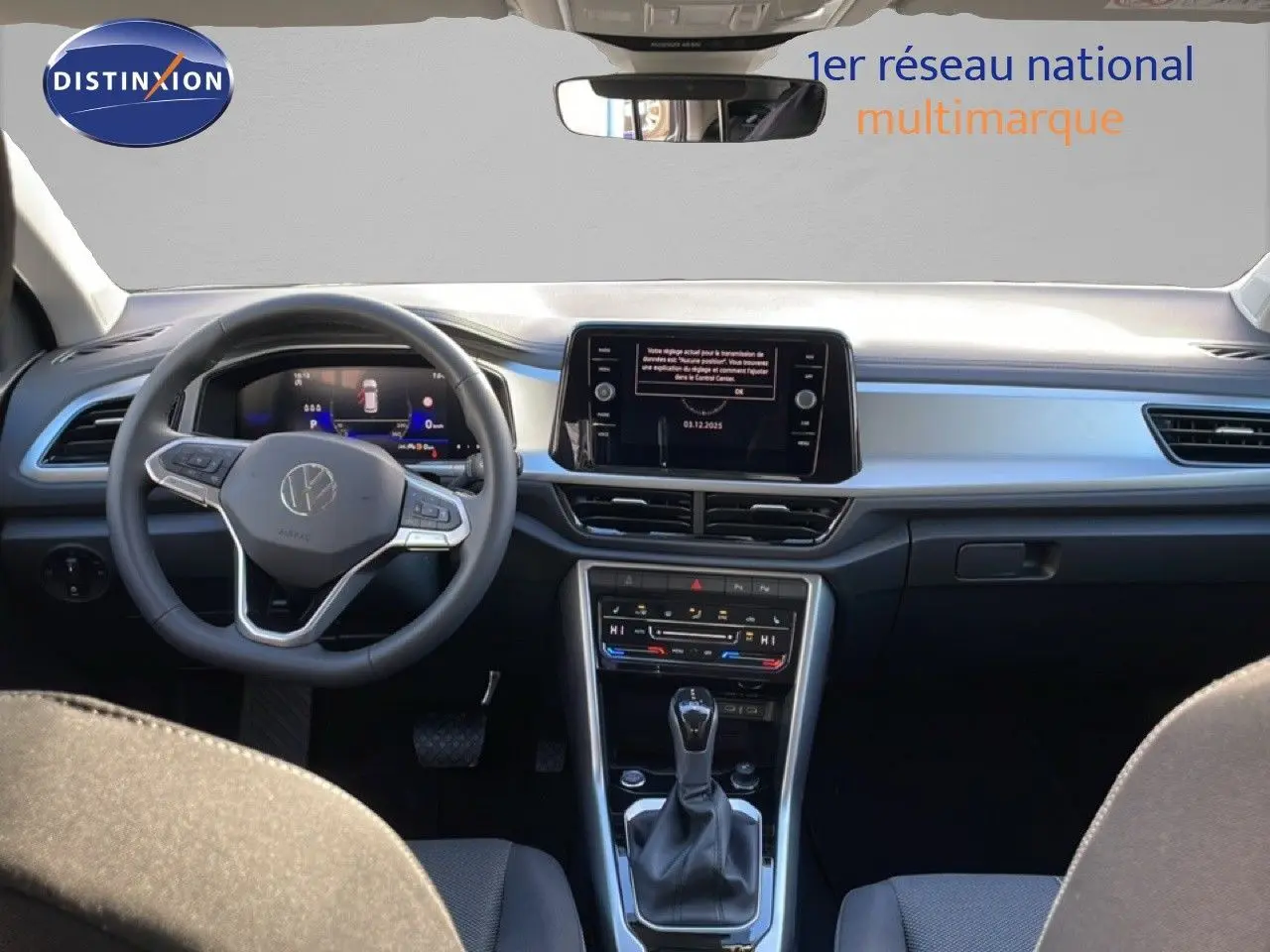 Vue intérieure avant du Volkswagen T-Roc 2025, montrant le tableau de bord moderne avec écran tactile et volant multifonction.