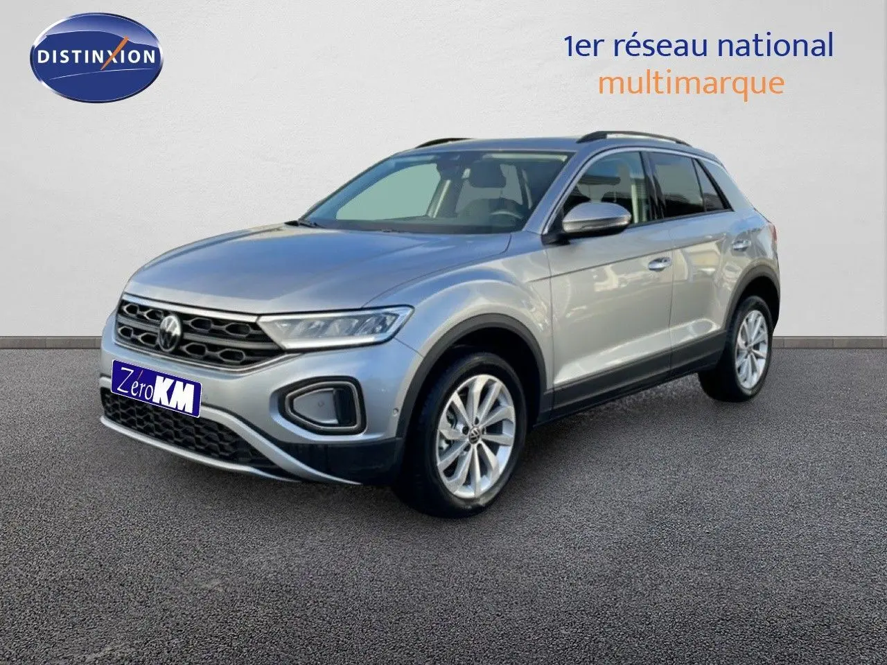 Vue 3/4 avant d'un Volkswagen T-Roc gris pyrite métallisé avec jantes alliage et calandre noire distinctive.