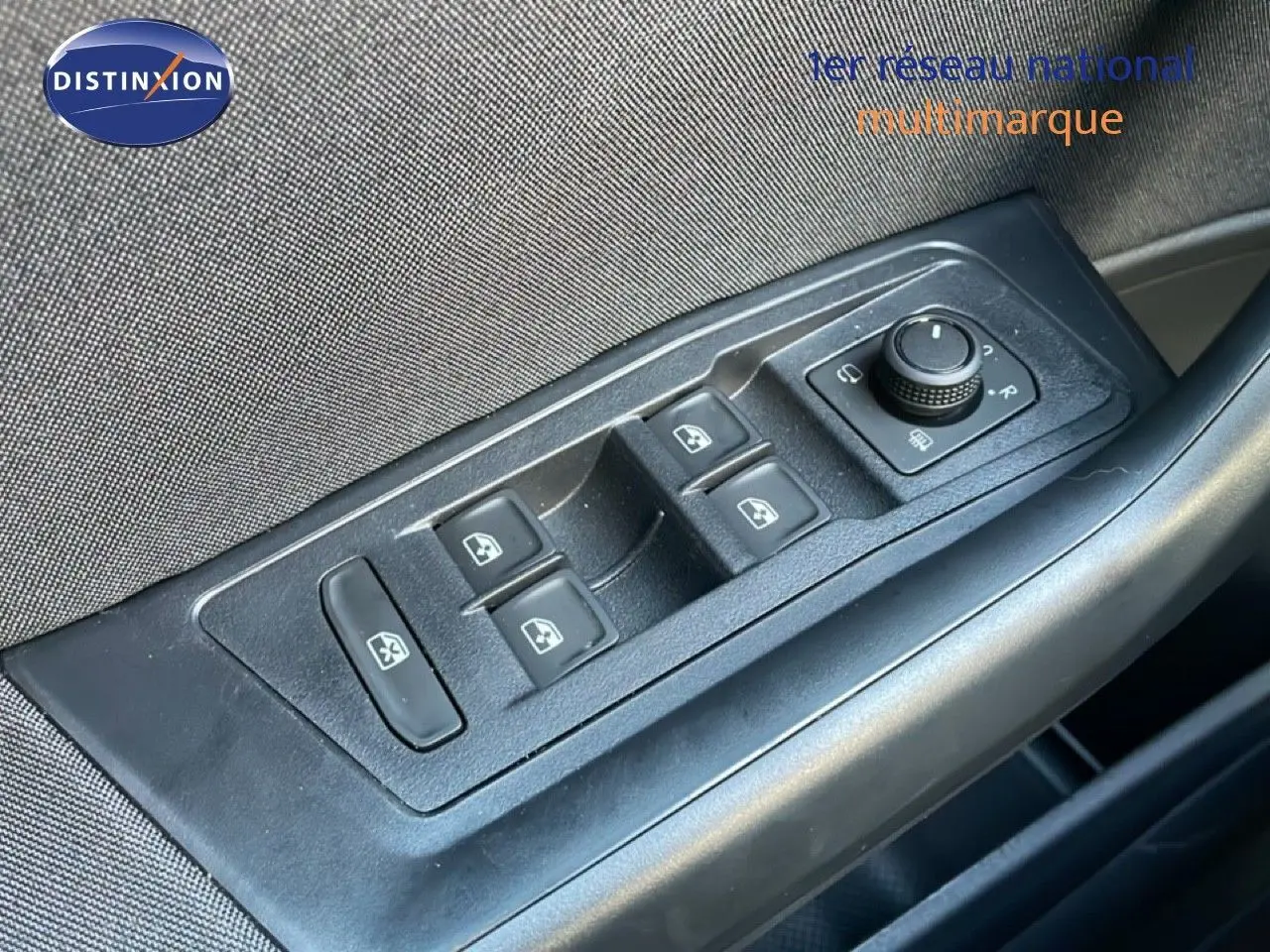 Gros plan sur les commandes de lève-vitres et rétroviseurs côté conducteur du Volkswagen T-Roc gris pyrite 2025.