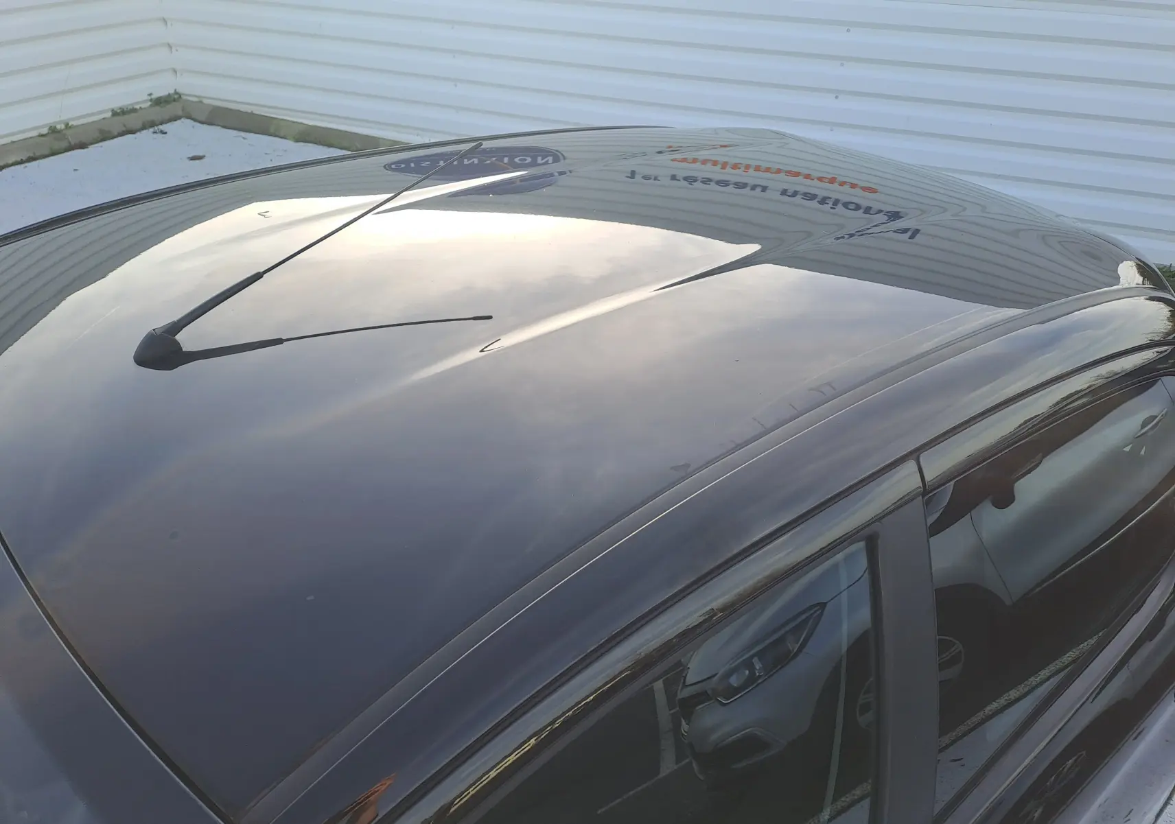 Toit noir brillant de la Peugeot 108 1.0 VTI 72CH ACTIVE vue en plongée, avec antenne centrale et reflet du ciel.