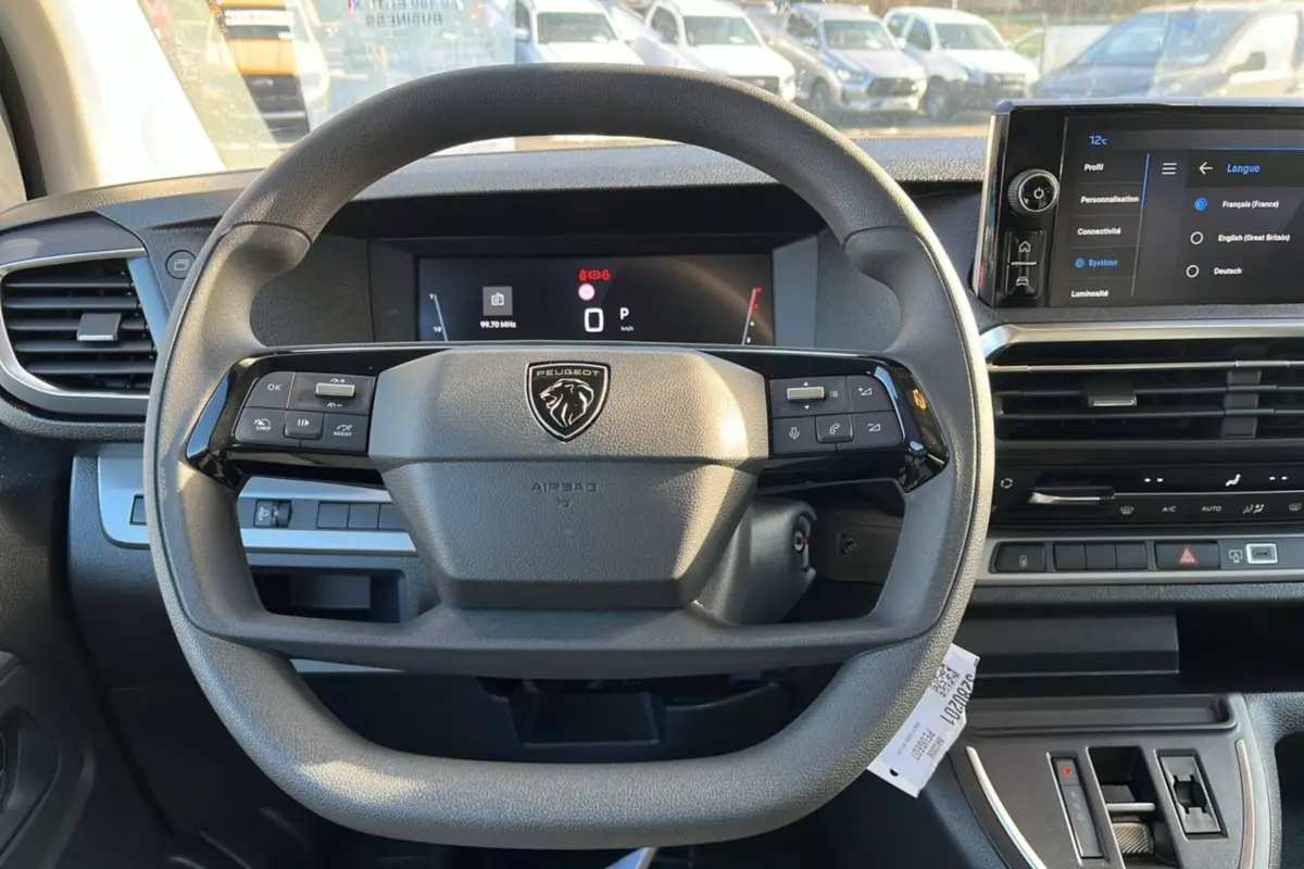 Vue intérieure centrée sur le volant multifonctions du Peugeot Traveller 2025 avec écran tactile et tableau de bord digital.