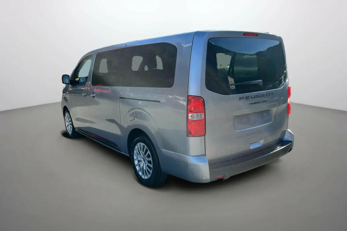 Peugeot Traveller gris acier vu 3/4 arrière droit avec vitres surteintées et portes latérales coulissantes.