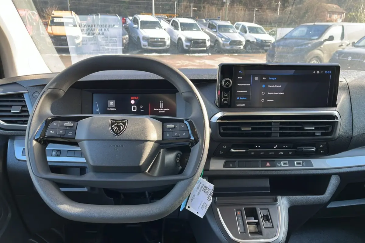 Vue intérieure frontale du tableau de bord du Peugeot Traveller 2025, avec volant multifonctions et écran tactile HD.