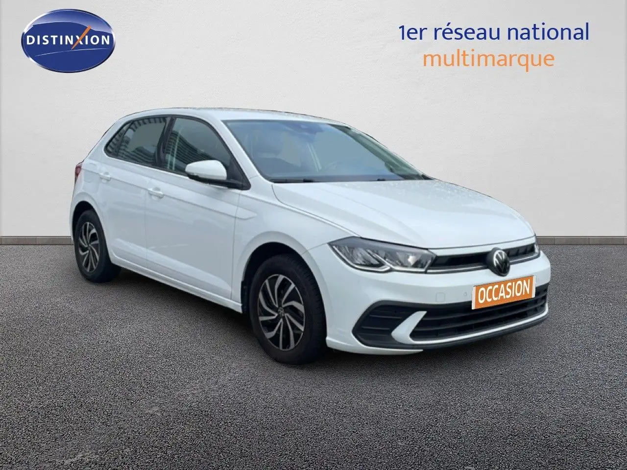 Volkswagen Polo blanc pur vue 3/4 avant droit avec jantes alliage et calandre moderne, en extérieur sur sol gris.