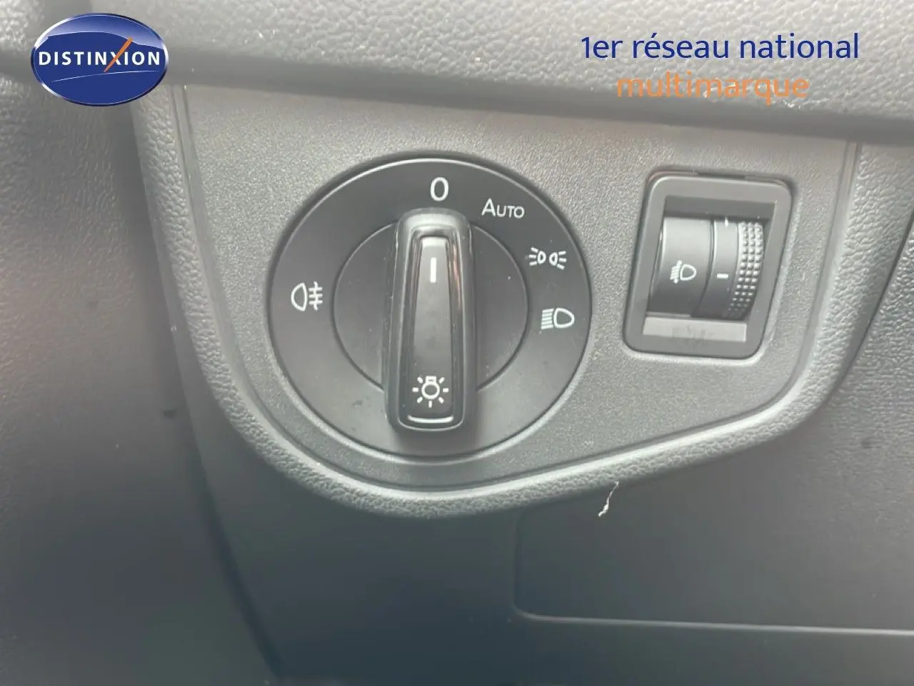 Gros plan sur le commutateur d'éclairage intérieur noir de la Volkswagen Polo blanche, avec réglage automatique et molette de réglage des phares.