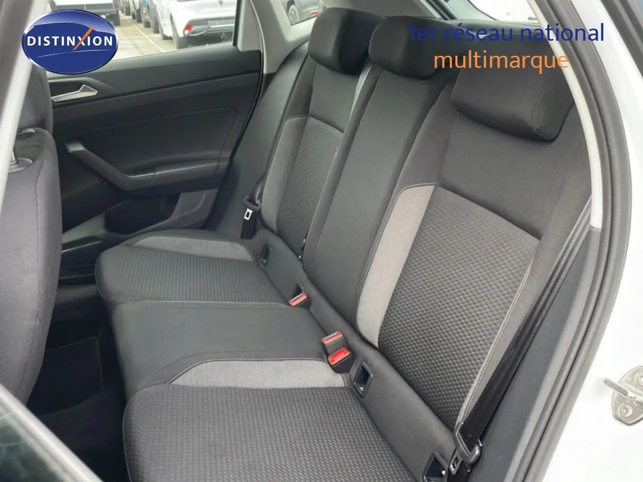 Vue intérieure sur la banquette arrière côté droit d'une Volkswagen Polo blanche avec sièges tissu noir et gris.