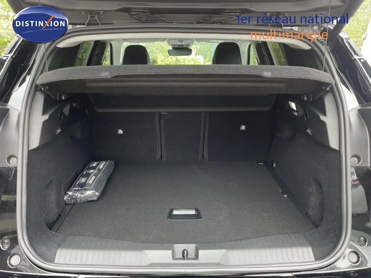 Coffre ouvert vu de l'arrière d'un Citroën C5 Aircross noir Perla Nera, montrant un espace de chargement spacieux et un cache-bagages.
