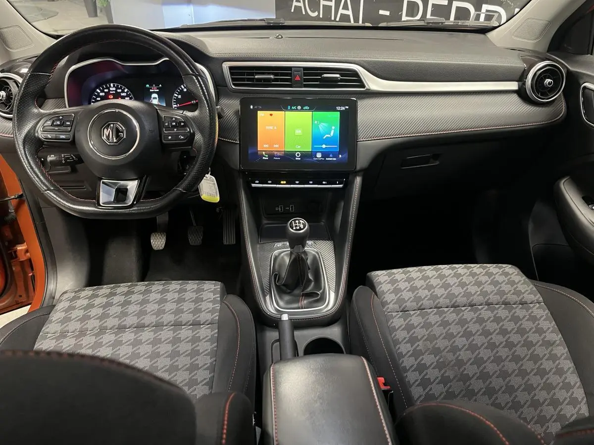 Vue intérieure avant du MG ZS 2022 avec volant cuir, écran tactile 10,1 pouces et sellerie tissu à motifs gris.