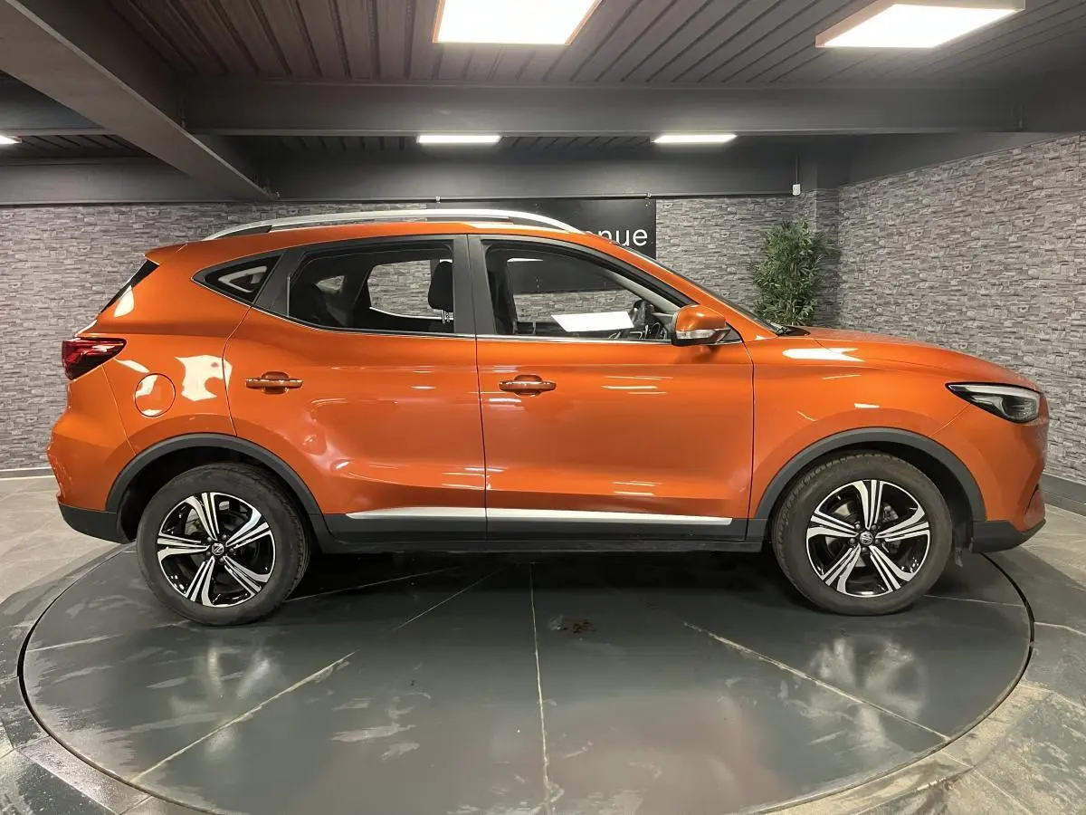 Vue latérale droite du MG ZS 2022 orange métallisé avec jantes alliage 17 pouces Typhoon et barres de toit.