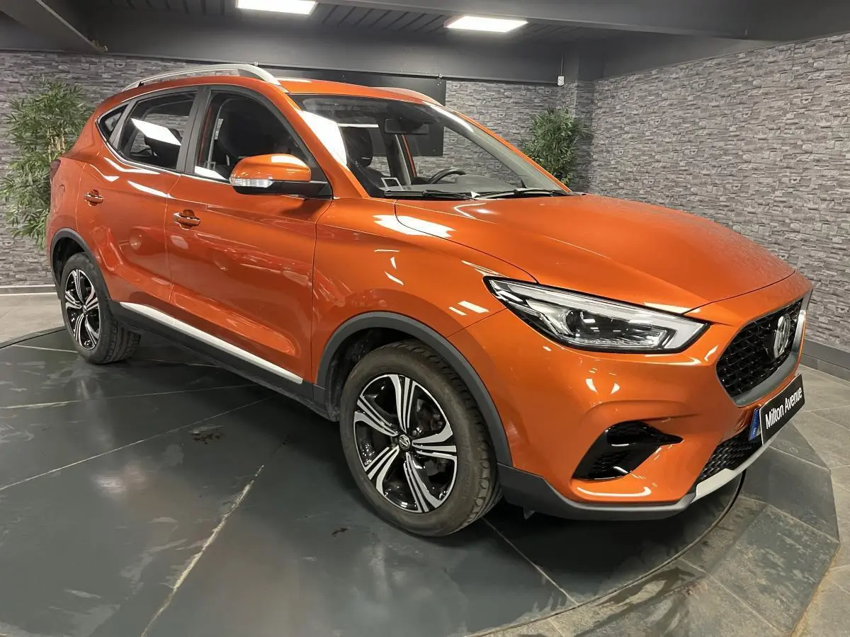 MG ZS 1.5L Tech 2022 orange métallisé en 3/4 avant droit avec jantes alliage et feux LED distinctifs.