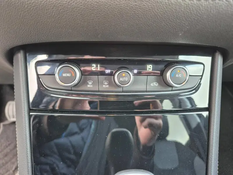 Vue rapprochée du panneau de climatisation automatique bi-zone noir brillant de l'Opel Grandland X 2020.