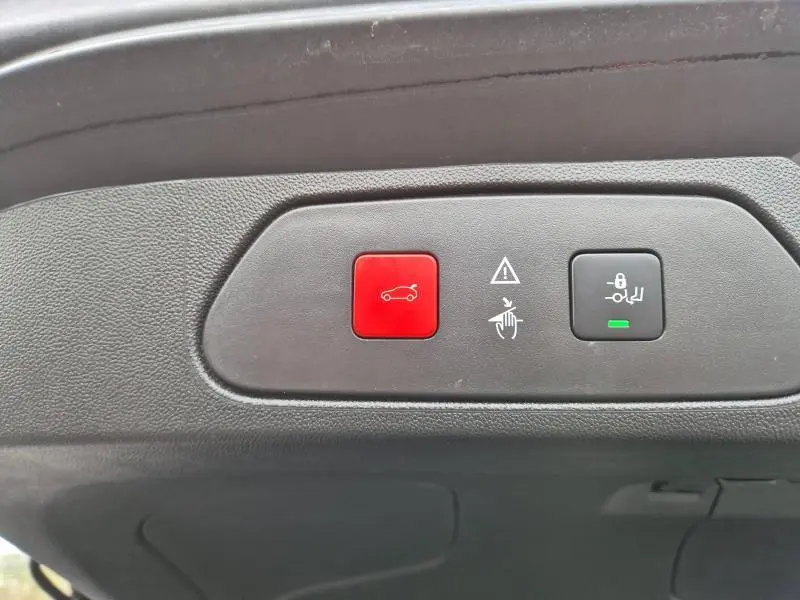 Boutons de commande du coffre et verrouillage enfant sur la plage arrière d’un Opel Grandland X noir Diamant 2020.