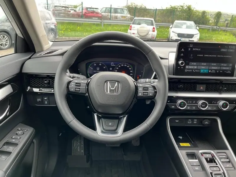 Vue intérieure frontale du tableau de bord noir du Honda CR-V 2024 avec volant cuir multifonction et écran tactile central.
