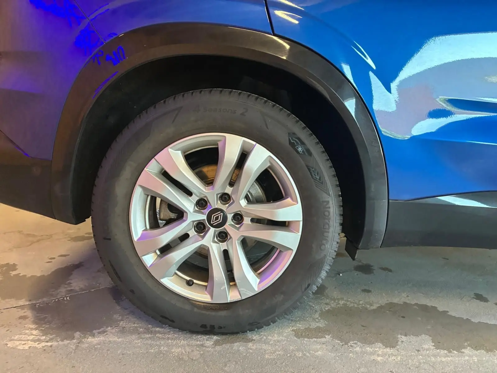 Gros plan sur la roue arrière gauche du Renault Austral bleu 2024, mettant en valeur la jante alliage et le passage de roue noir.