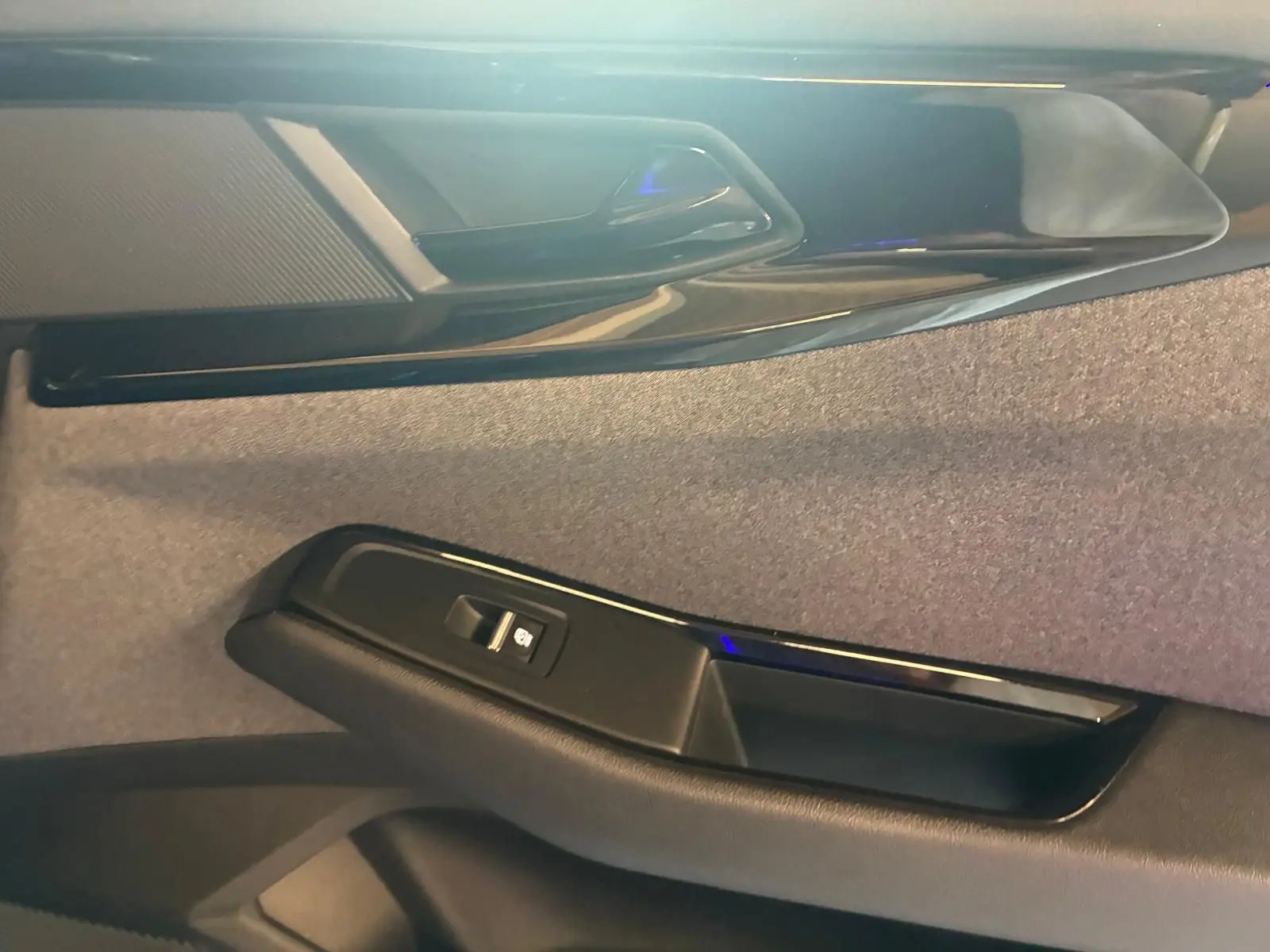 Détail de la porte intérieure côté droit du Renault Austral 2024, avec bouton de commande de vitre et finition tissu gris noir.