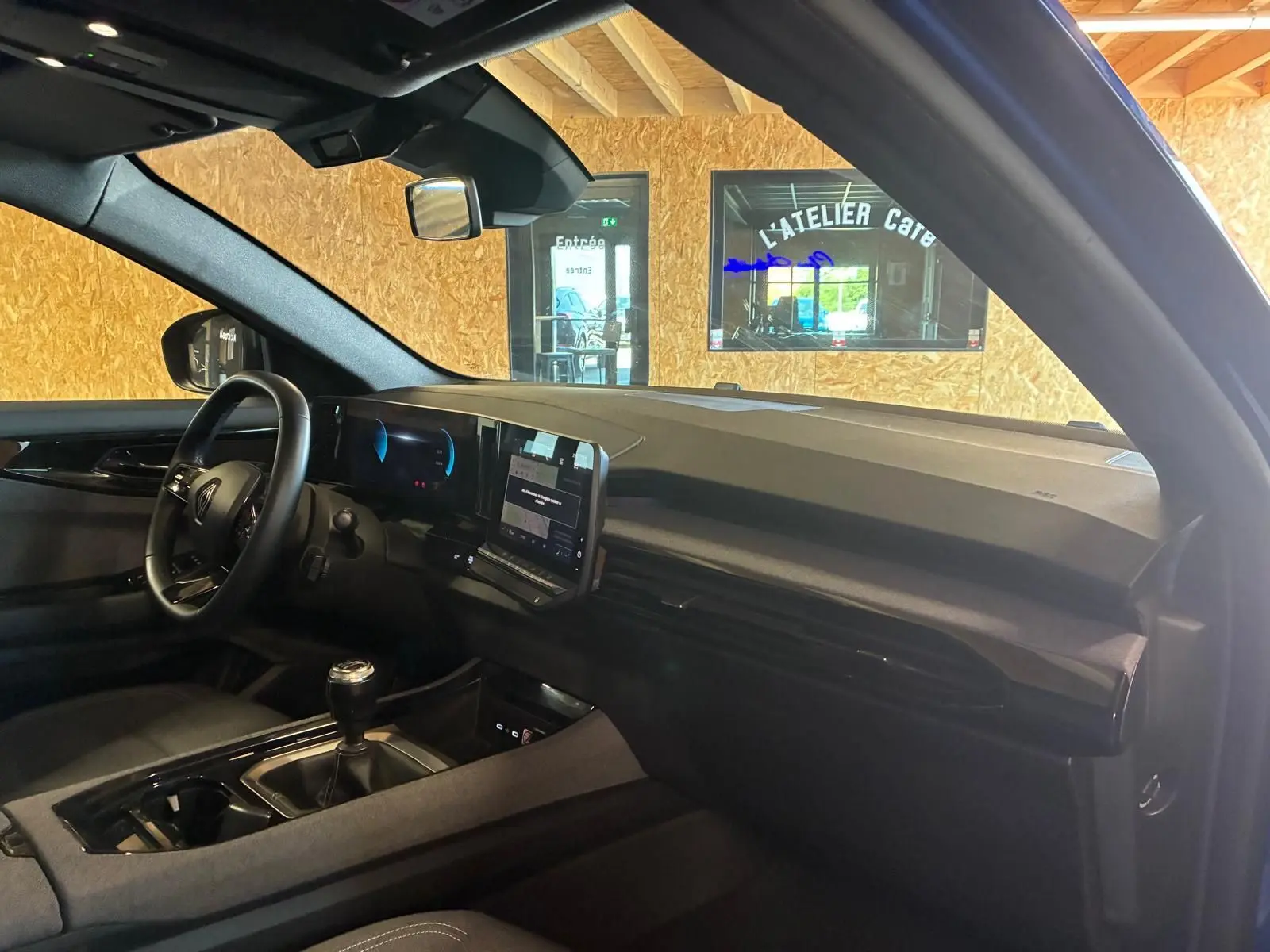 Vue intérieure côté conducteur du Renault Austral 2024, avec tableau de bord noir et écran tactile central.