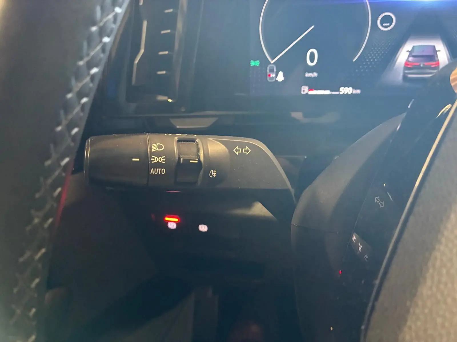 Gros plan sur la manette de clignotants et phares automatiques du tableau de bord du Renault Austral 2024, intérieur noir.