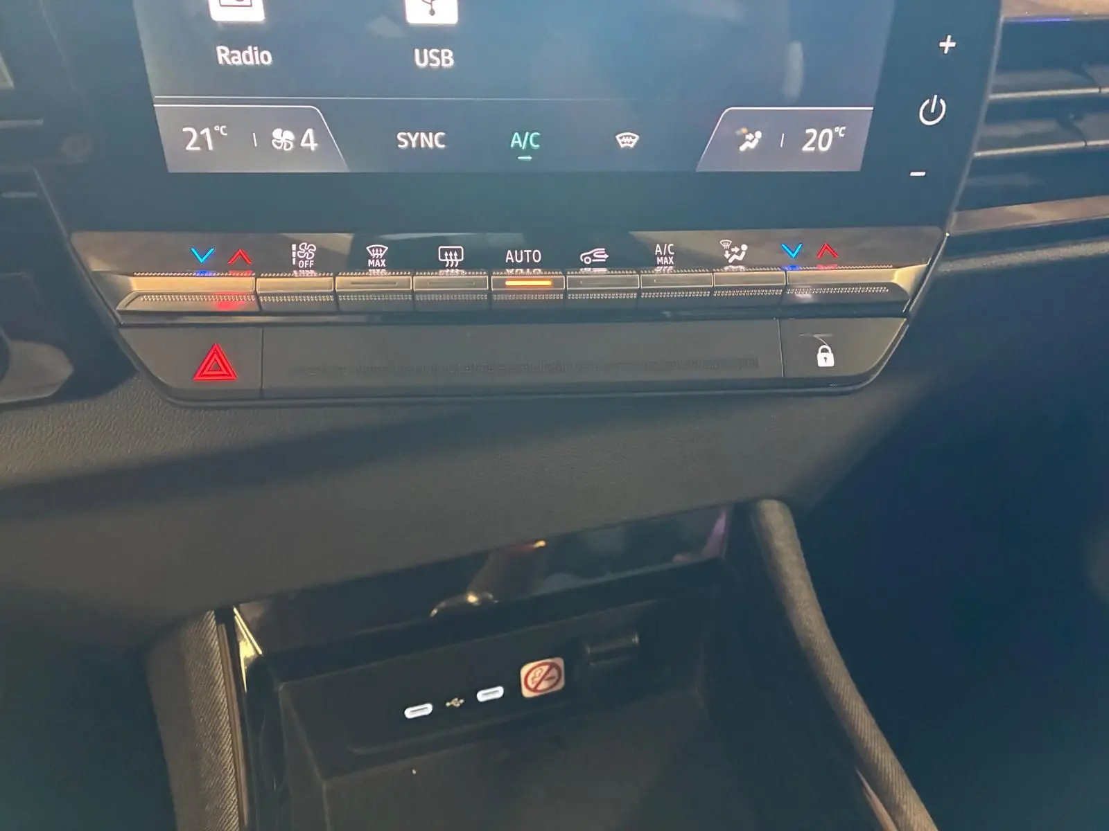 Gros plan sur la console centrale du Renault Austral bleu 2024, montrant les commandes climatisation et ports USB.