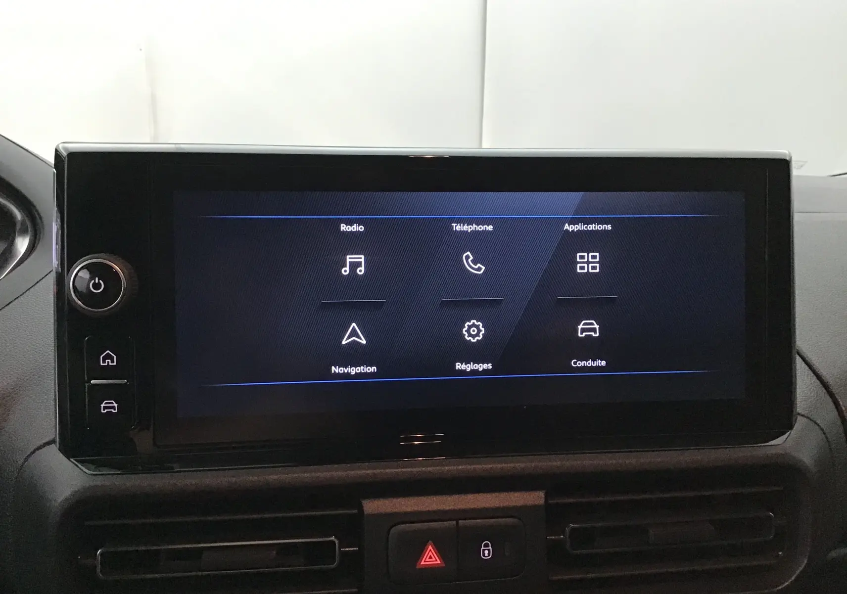 Écran tactile central du tableau de bord du Peugeot Partner blanc, affichant les menus radio, téléphone et navigation.