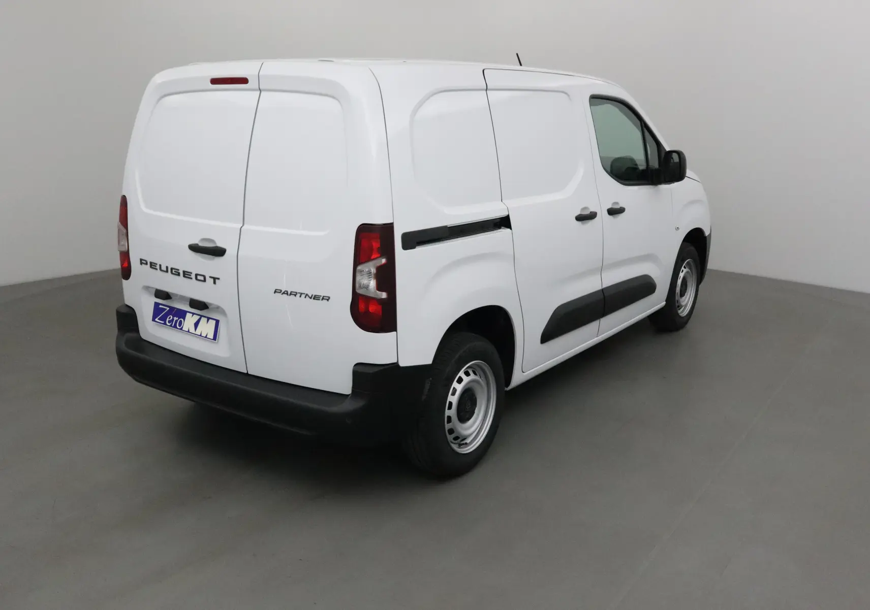 Vue 3/4 arrière droite d'un utilitaire Peugeot Partner blanc avec portes arrière battantes et jantes acier.