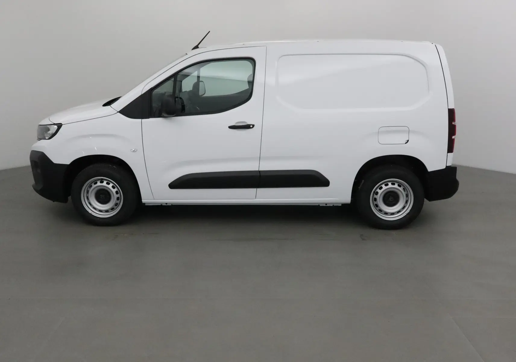 Peugeot Partner blanc vu de profil côté gauche, fourgonnette utilitaire avec protections noires sur les portières.