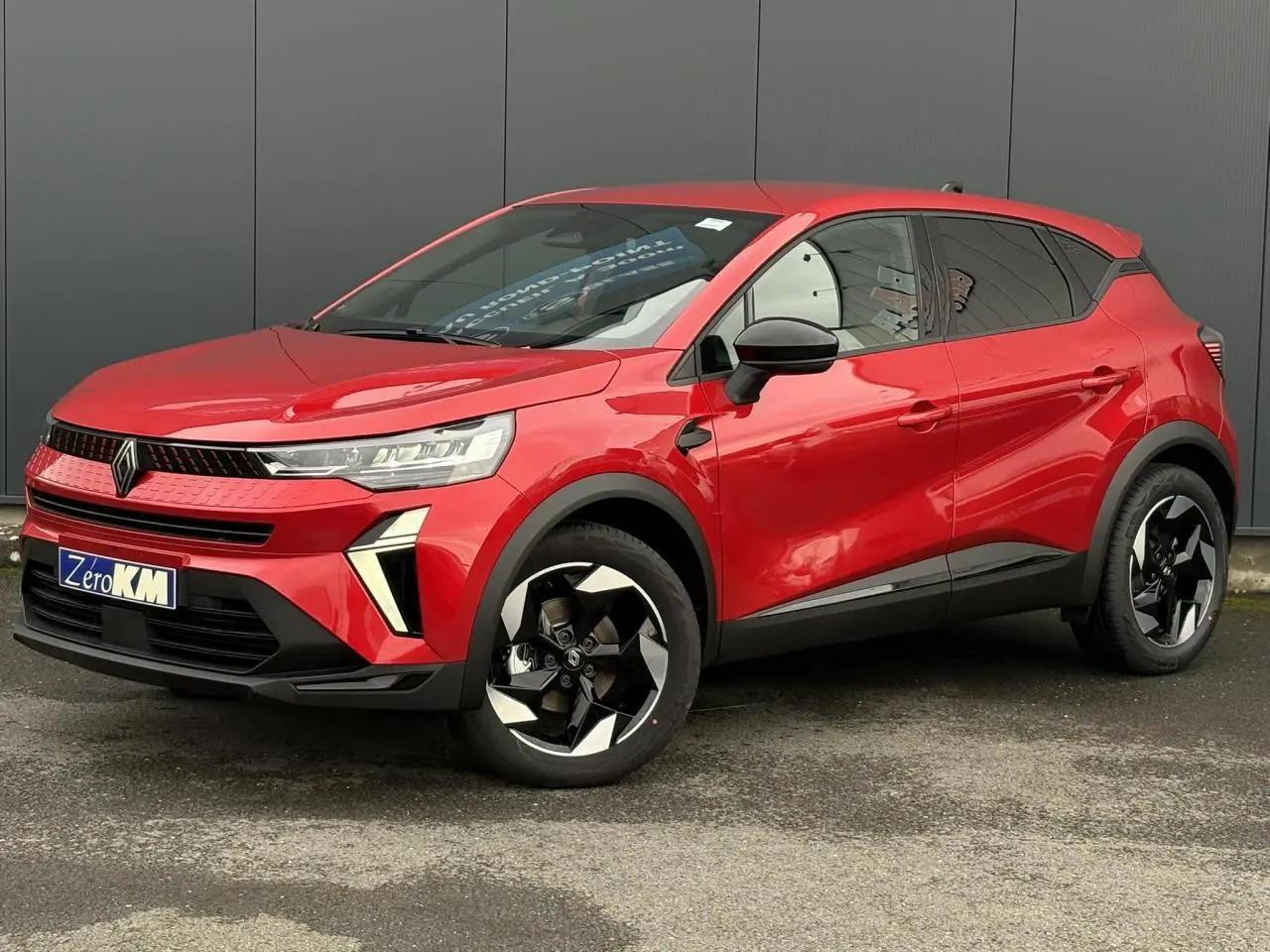 Vue 3/4 avant droite d'un Renault Captur Rouge Flamme avec jantes noires et détails noirs brillants.
