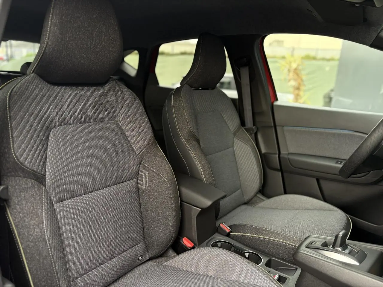 Vue intérieure des sièges avant gris foncé du Renault Captur 2026 avec console centrale et levier de vitesse automatique.