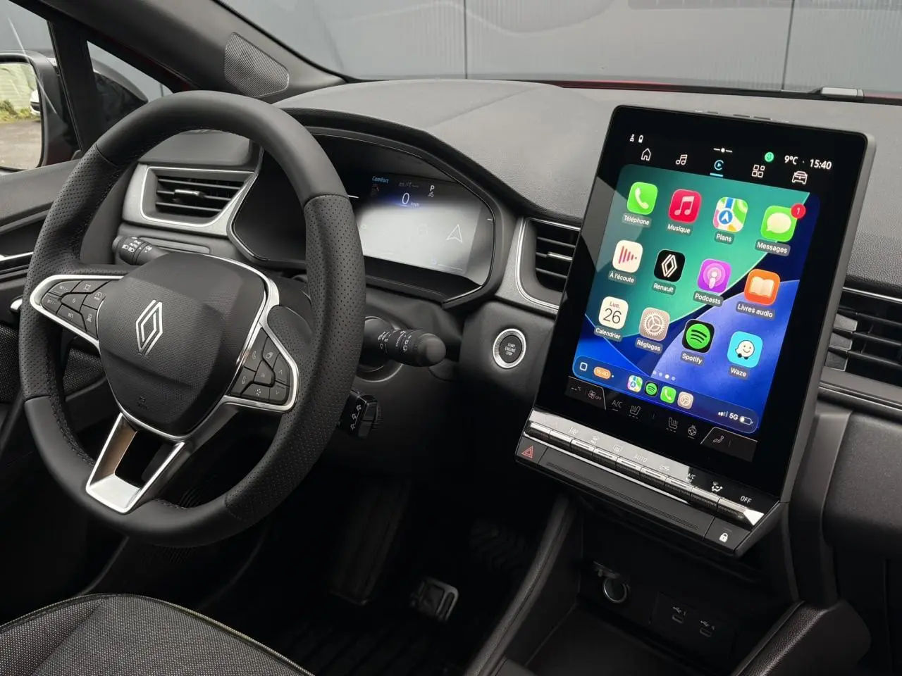 Vue intérieure du tableau de bord du Renault Captur 2026, avec écran tactile vertical et volant multifonction noir.