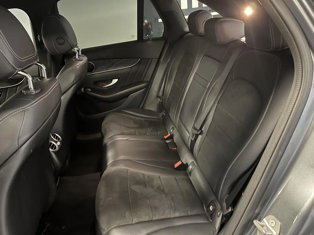 Vue intérieure côté droit des sièges arrière noirs en similicuir avec surpiqûres contrastées d'un Mercedes GLC Sportline 2019.