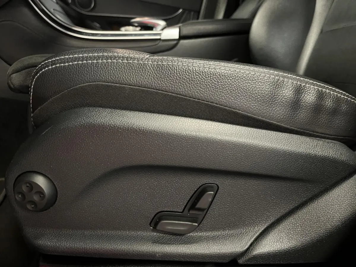 Détail de la commande électrique du siège avant en cuir noir du Mercedes GLC 220 d Sportline 2019.