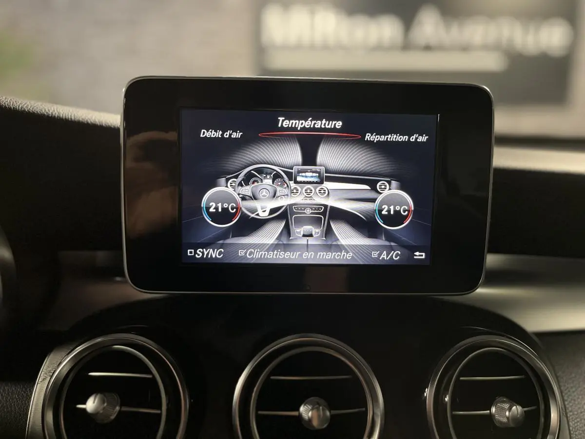 Écran central du tableau de bord du Mercedes GLC 220 d 2019 affichant la climatisation à 21°C, avec aérateurs ronds chromés.