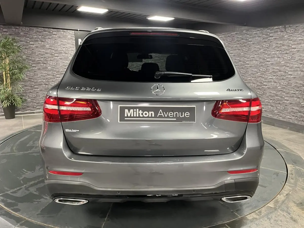 Vue arrière d'un Mercedes GLC 220 d gris métallisé avec feux LED et double sorties d'échappement chromées.