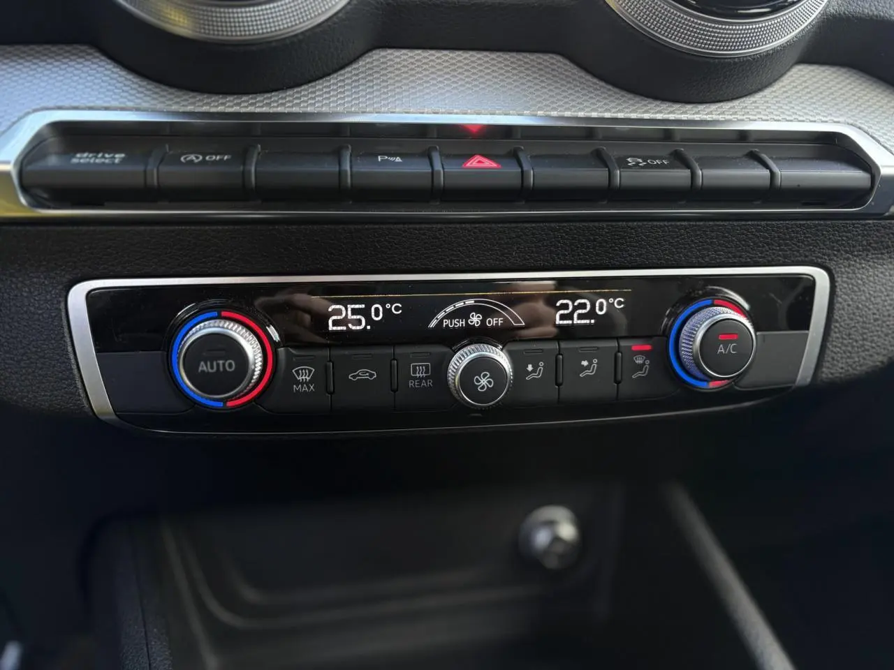 Vue rapprochée de la console centrale de l'Audi Q2 30 TDI 116 S-Line, montrant la climatisation automatique bi-zone.