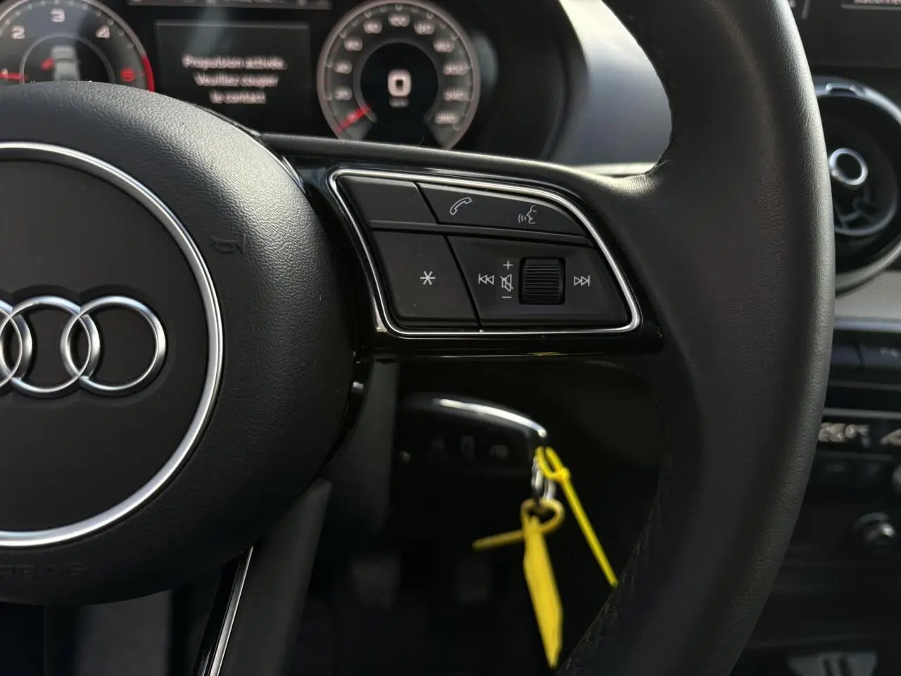 Gros plan sur le volant cuir multifonction de l'Audi Q2 30 TDI S-Line 2025 avec commandes audio et téléphone.