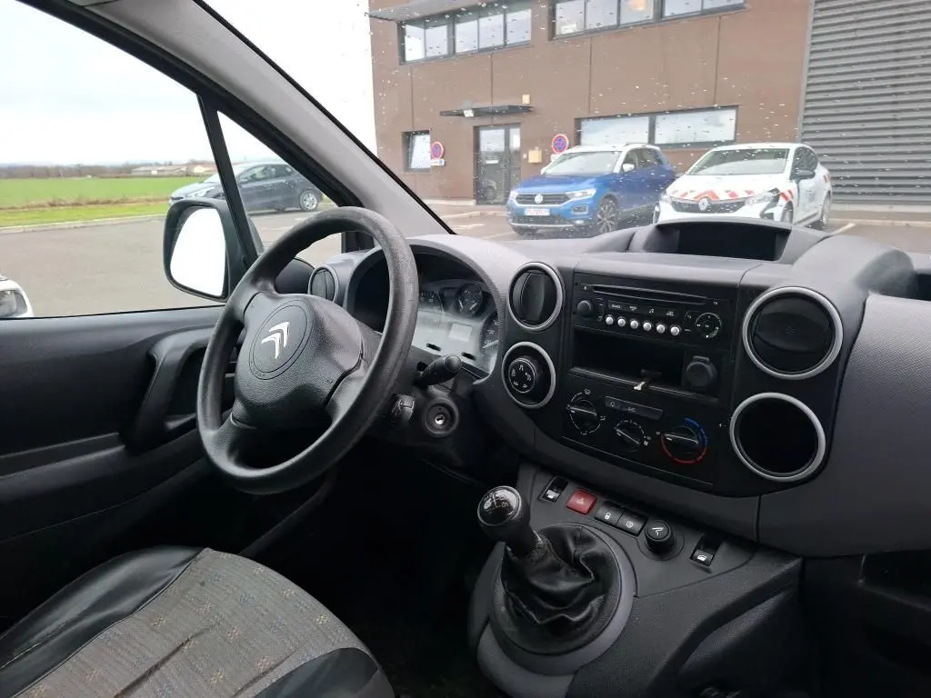 Vue intérieure côté conducteur du Citroën Berlingo blanc 2019, montrant volant, tableau de bord et levier de vitesses manuel.