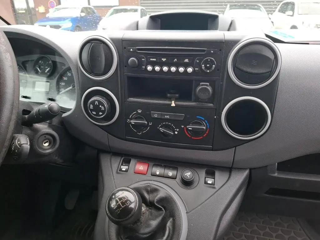 Vue intérieure du tableau de bord d'un Citroën Berlingo blanc 2019, avec boîte manuelle et commandes de climatisation visibles.