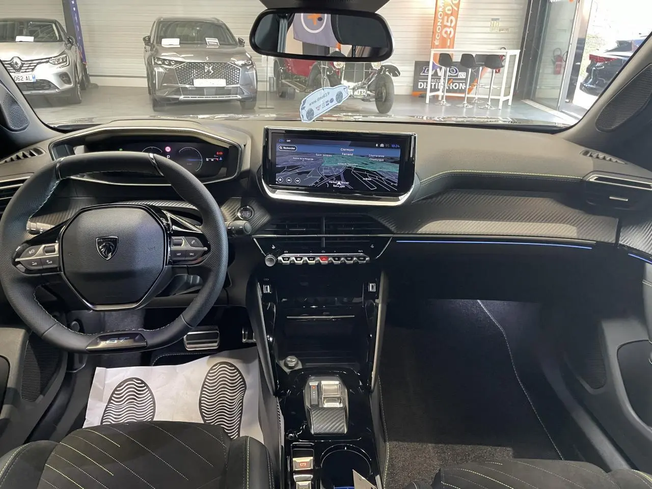 Vue intérieure avant du Peugeot 2008 gris hybride, mettant en valeur le tableau de bord numérique et l’écran tactile central.