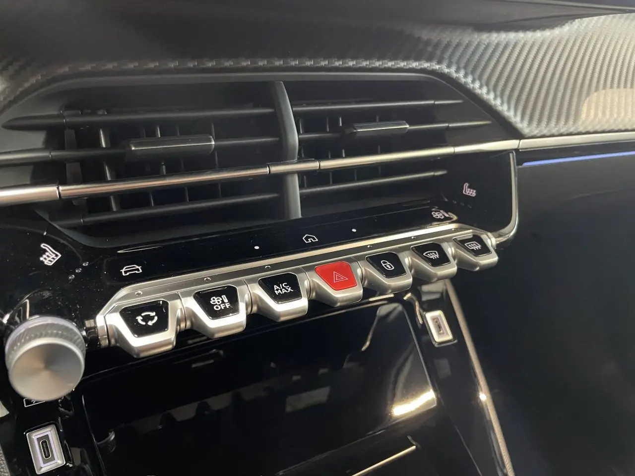 Gros plan sur la console centrale du Peugeot 2008 gris 2026, montrant les commandes tactiles et les aérateurs horizontaux.
