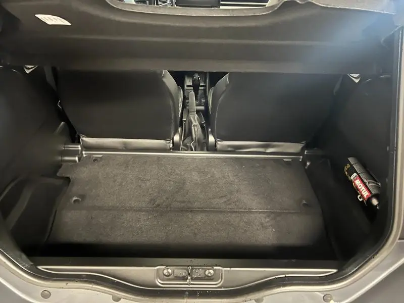 Coffre ouvert d'une Ligier JS50 Sport Elite E5+ gris 2025, vue arrière montrant l'espace de chargement et les sièges avant.