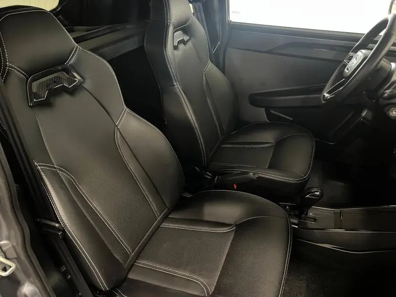 Intérieur côté conducteur de la Ligier JS50 Sport Elite E5+ 2025, sièges noirs avec surpiqûres blanches et volant visible.
