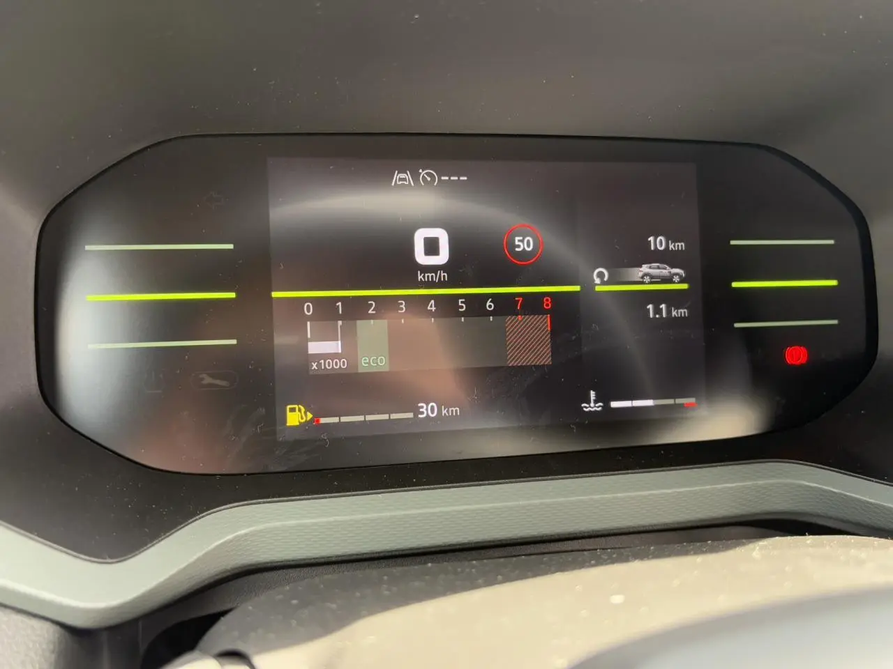 Tableau de bord digital du Dacia Duster 2025 affichant vitesse, régime moteur et autonomie, vue frontale.