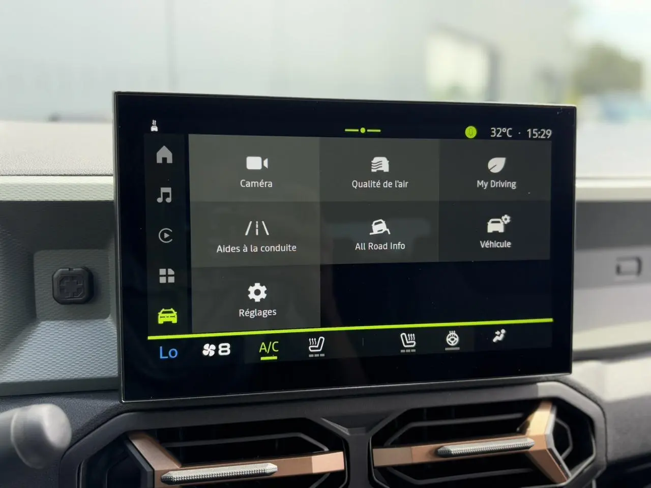 Écran tactile 10 pouces du tableau de bord du Dacia Duster 2025, avec interface climatisation et aides à la conduite.