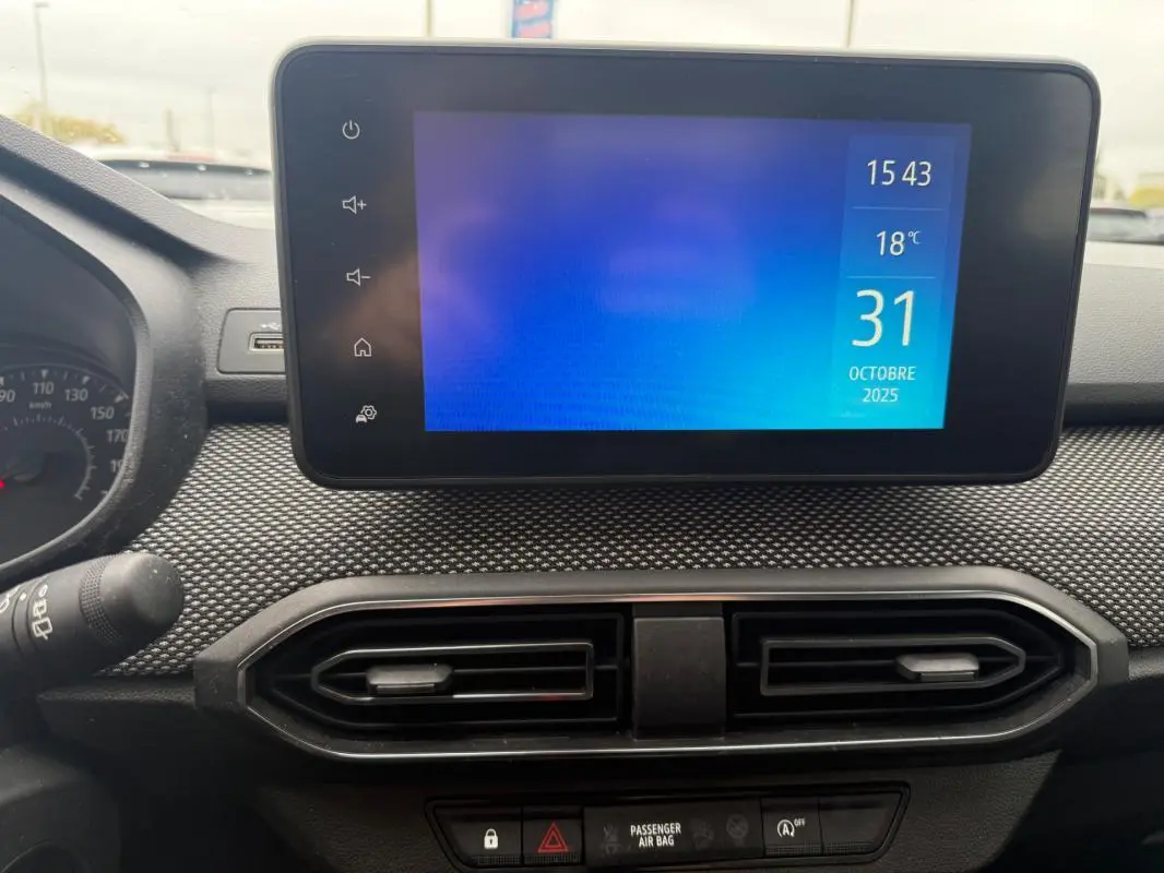 Vue rapprochée de l'écran tactile central et des aérateurs du tableau de bord de la Dacia Sandero blanche 2021.