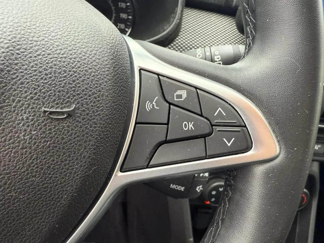 Gros plan sur les commandes du volant côté droit d'une Dacia Sandero blanche, version SCe 65 Confort 2021.