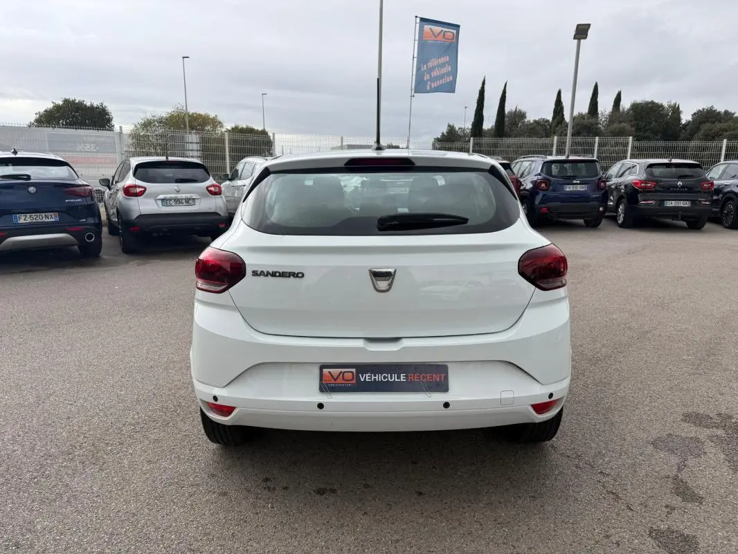 Vue arrière d'une Dacia Sandero blanche 2021, avec feux rouges et logo au centre du hayon.