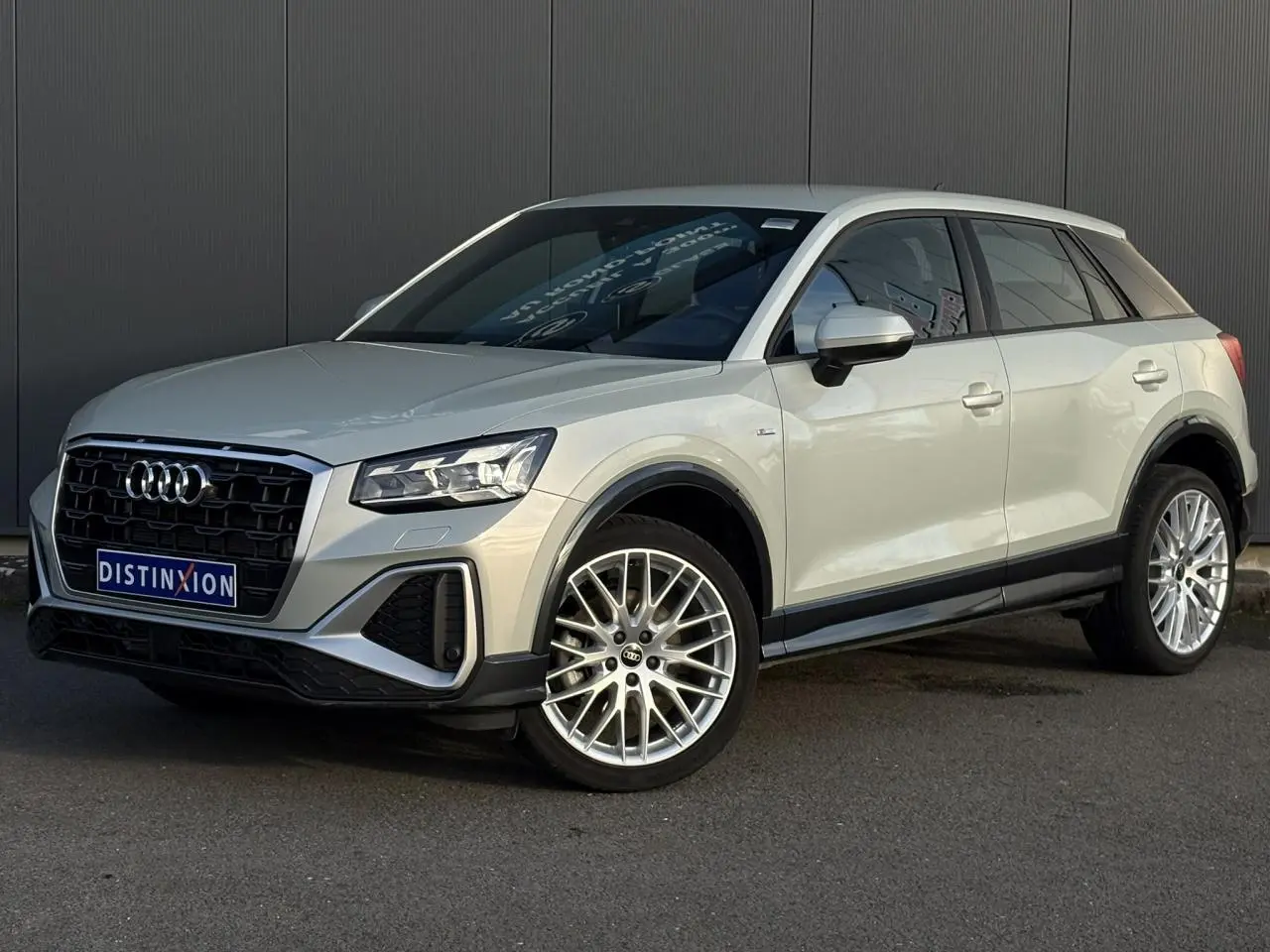 Audi Q2 35 TDI S-Line argent rosé, vue 3/4 avant droit, avec jantes alliage et calandre noire distinctive.
