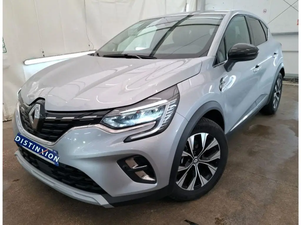 Renault Captur II Techno gris Highland en vue 3/4 avant droit, avec jantes alliage bicolores et rétroviseurs noirs.